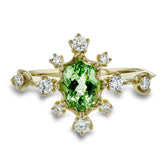 This 18k yellow gold fashion ring is set with .28 ctw of diamonds and a bright tsavorite garnet center stone.