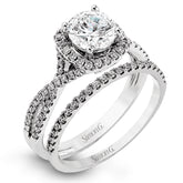 Presenting a lovely twisted shank design, this contemporary white gold engagement ring and wedding band set is accentuated with .44 ctw round cut white diamonds.