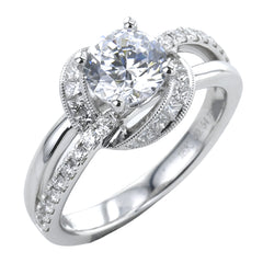 This 18K white gold engagement ring has a split shank design with RD diamonds 0.21 ctw. on one side and high polish on the other side, and a diamond halo with fine millgrain trim, of princess cut stones 0.33 ctw.