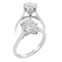 This elegant white gold engagement ring takes a pear shape center and is adorned with a delicate under halo, and a line of diamonds on the side profile 0.13 ctw