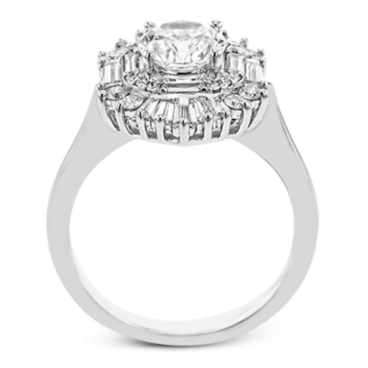 Crafted in 18K white gold, this distinctive ring is an ode to Art Deco design & features a halo of RD diamonds 0.23 ctw, surrounded by a burst of baguette shaped diamonds 0.70 ctw.
