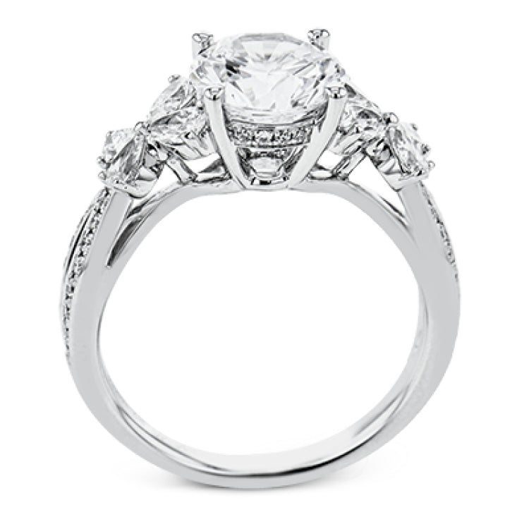 A beautiful engagement ring perfect for those who love floral inspired designs. It features a split shank setting with diamond accents .20ctw., & 8 pear shaped diamonds .62ctw. that create the look of petals around the center stone.