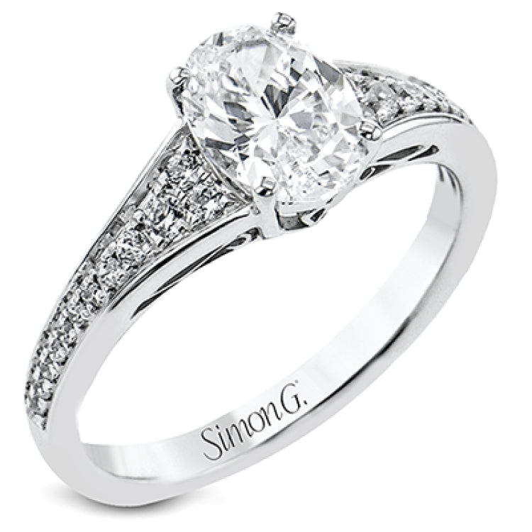 This white gold engagement ring takes an oval center stone and has a tapered shank, with diamonds .22 ctw graduating in size down the sides. On the profile there is hand carved filligree design.