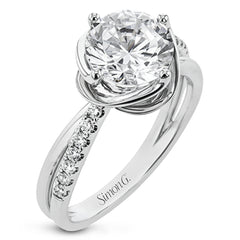 This criss-cross design engagement ring shimmers with 0.15 ctw round diamonds and a halo of gold strands wrapped around the center