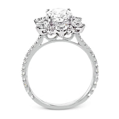 Like a crystallized explosion of light, this remarkable engagement ring design features a supernova of .60 ctw of diamonds surrounding the oval shaped center stone, as well as .38 ctw of smaller diamonds down the band.