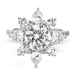 Pear shaped diamonds are set into a pointed halo that expands outward like a cosmic explosion in this Supernova Collection engagement ring.