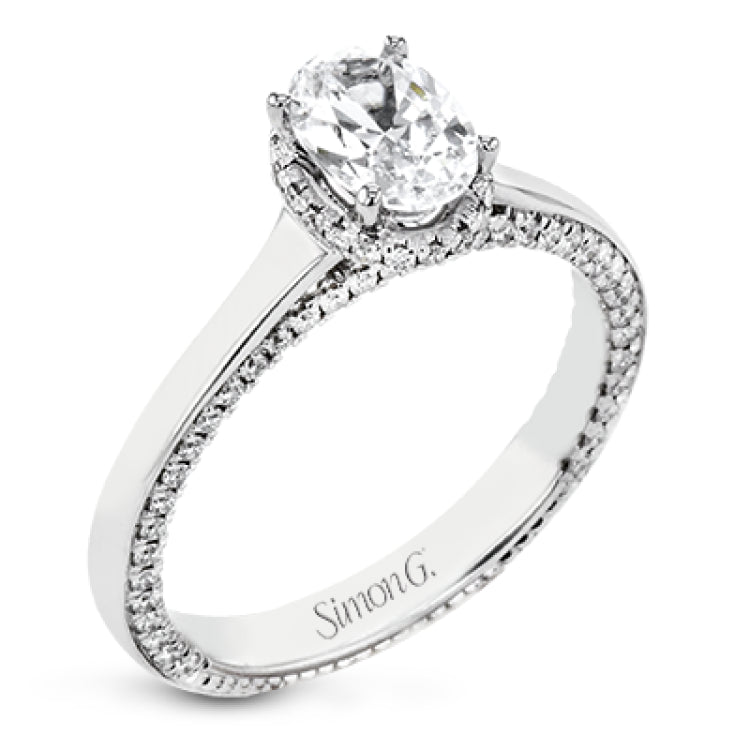 This engagement ring is made from an oval center stone and features a low halo as well as diamonds extended down the sides of the ring.