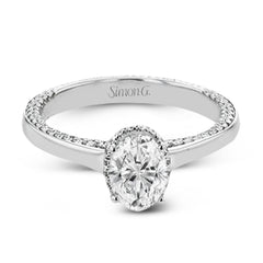 This engagement ring is made from an oval center stone and features a low halo as well as diamonds extended down the sides of the ring.