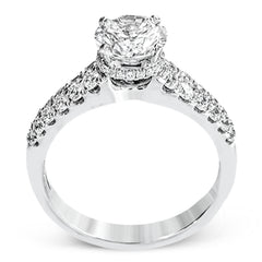 Shining white diamonds encircle the center stone in this Underhalo engagement ring, while also extending across the sides of the ring to ensure it glitters from all directions.