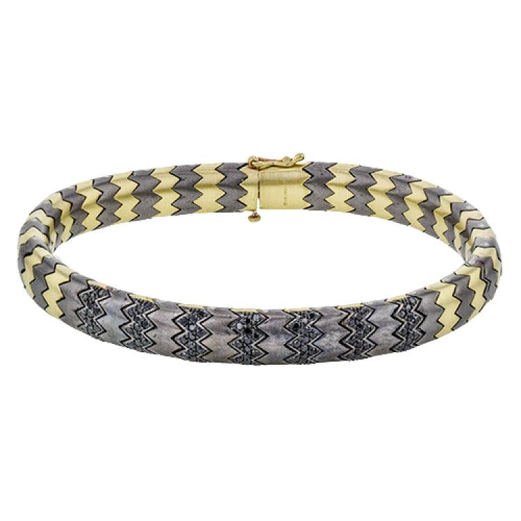 This stunning bracelet is wrought from 14k gold and titanium, and features .74 ctw of black diamonds set into its zigzag pattern.