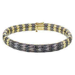 This stunning bracelet is wrought from 14k gold and titanium, and features .74 ctw of black diamonds set into its zigzag pattern.