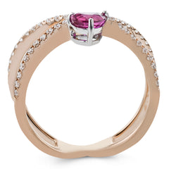 This modern 18k rose gold ring features a .61 ctw pear shaped ruby stone set against an angle, and is accented by .22 ctw of white diamonds.