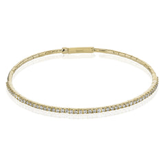 This 18K yellow gold bangle bracelet featuring .76ctw diamonds is perfect for everyday wear or a night out on the town. This wardrobe staple pairs perfectly with any jewelry collection.