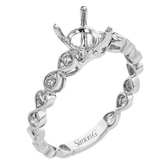 This wedding set features a white gold vintage inspired engagement ring in the center with a yellow gold granulated ring guard that provides a unique look.