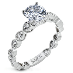 This wedding set features a white gold vintage inspired engagement ring in the center with a yellow gold granulated ring guard that provides a unique look.