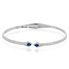This modern hinged bangle adds a touch of color with two precious gemstone accent, set off by .30 ctw of white diamonds along the sides.