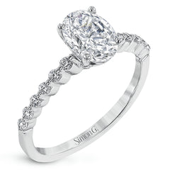 This contemporary wedding set features .48 ctw of diamond side stones and is designed to perfectly showcase an oval center stone.