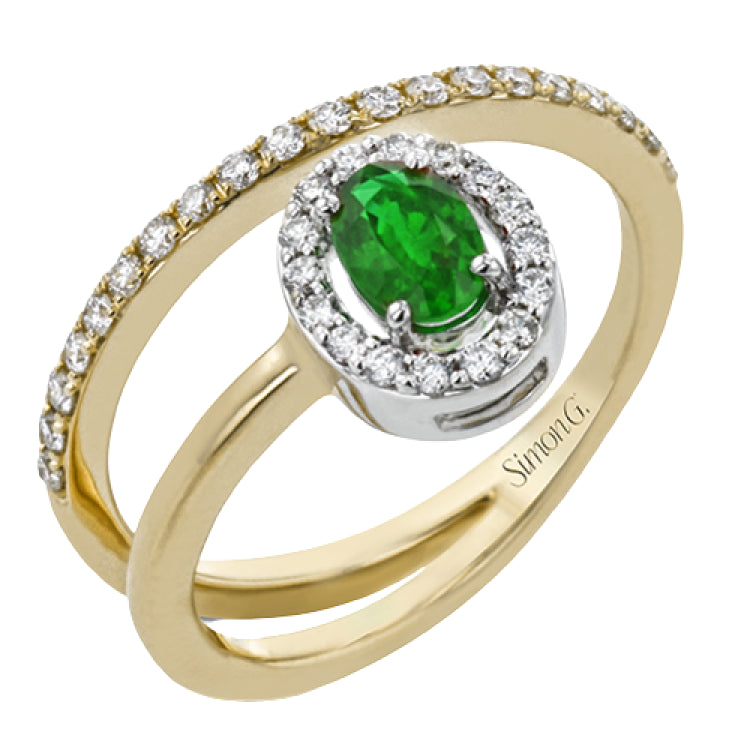 This exceptional ring crafted from 18k yellow gold is set with an oval shaped emerald and .33 ctw of white diamonds.