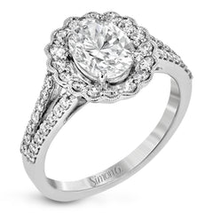 This delightful engagement ring features a scalloped halo that surrounds the center stone like a flower, containing .52 ctw of white diamonds.