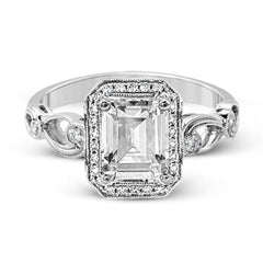 Reflecting a lovely romantic design, this white gold classic engagement ring features .16 ctw round cut white diamond accents.