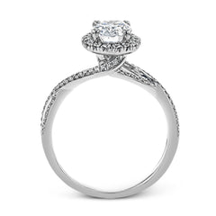 This sparkling modern engagement ring features an eye-catching twisted design with elegant classic halo accented by .29 ctw of shimmering round cut white diamonds.
