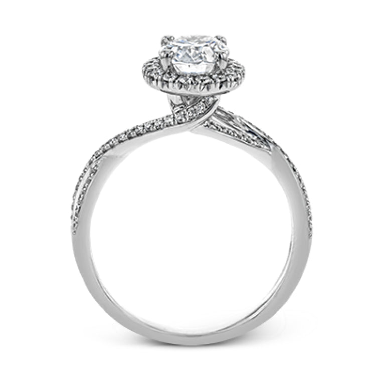 This sparkling modern engagement ring features an eye-catching twisted design with elegant classic halo accented by .29 ctw of shimmering round cut white diamonds.