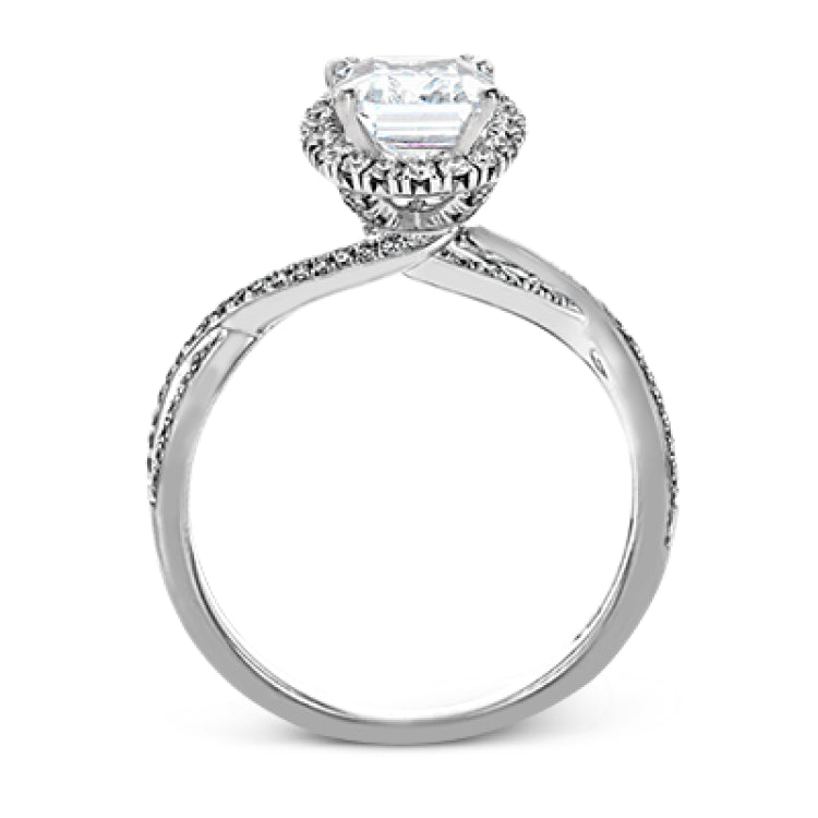 This sparkling modern engagement ring features an eye-catching twisted design with elegant classic halo accented by .29 ctw of shimmering round cut white diamonds.