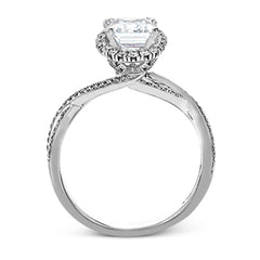 This sparkling modern engagement ring features an eye-catching twisted design with elegant classic halo accented by .29 ctw of shimmering round cut white diamonds.