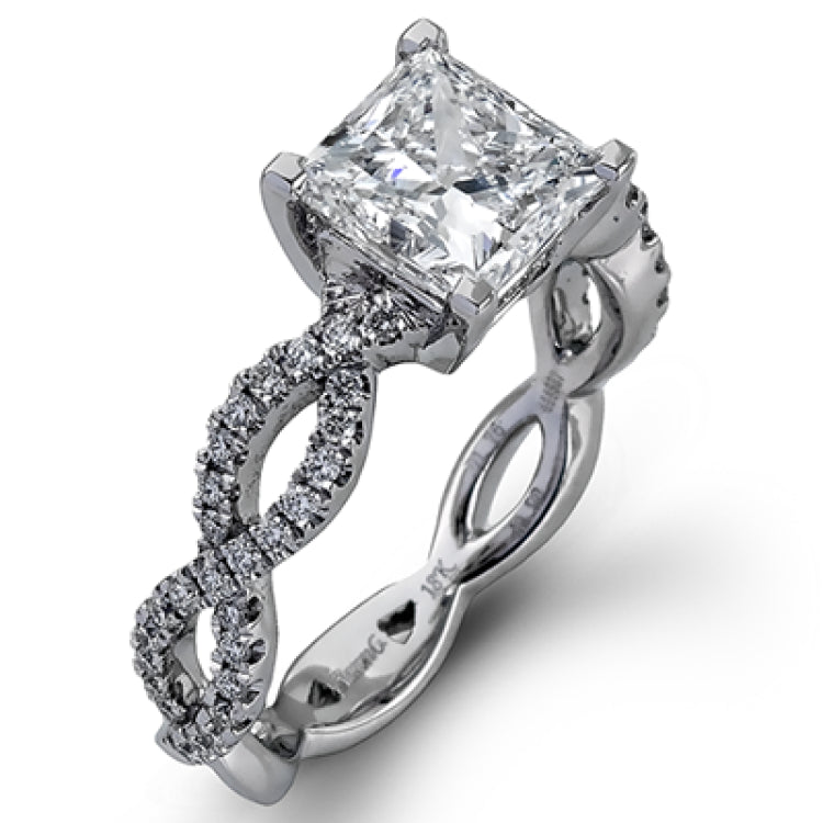 The intricate twisted design of this modern white gold engagement ring and wedding band set is set with .65 ctw of striking round cut white diamonds.