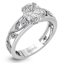 A delicate floral design highlights this vintage style engagement ring accented by .09 ctw of shimmering round cut white diamonds.