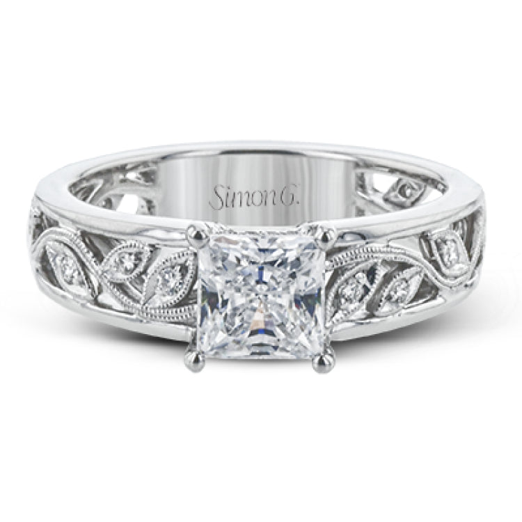 A delicate floral design highlights this vintage style engagement ring accented by .09 ctw of shimmering round cut white diamonds.