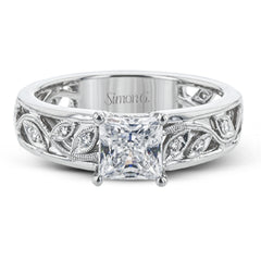 A delicate floral design highlights this vintage style engagement ring accented by .09 ctw of shimmering round cut white diamonds.