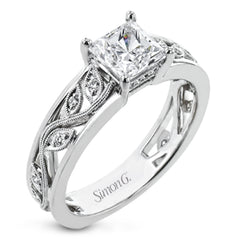 A delicate floral design highlights this vintage style engagement ring accented by .09 ctw of shimmering round cut white diamonds.