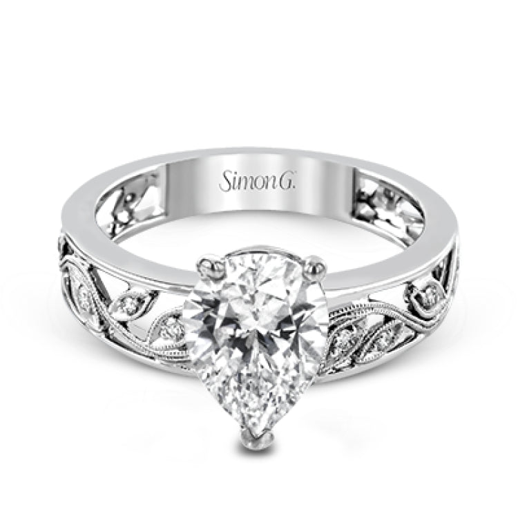 A delicate floral design highlights this vintage style engagement ring accented by .09 ctw of shimmering round cut white diamonds.