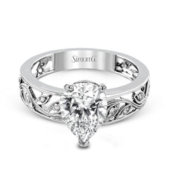 A delicate floral design highlights this vintage style engagement ring accented by .09 ctw of shimmering round cut white diamonds.