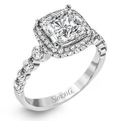 The delicate design of this classic white gold engagement ring features a sparkling pave halo accented with .86 ctw of shimmering round cut white diamonds.