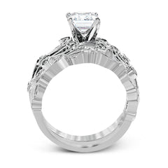 This delicate floral inspired white gold engagement ring and wedding band set is accentuated with .28 ctw shimmering round cut white diamonds.