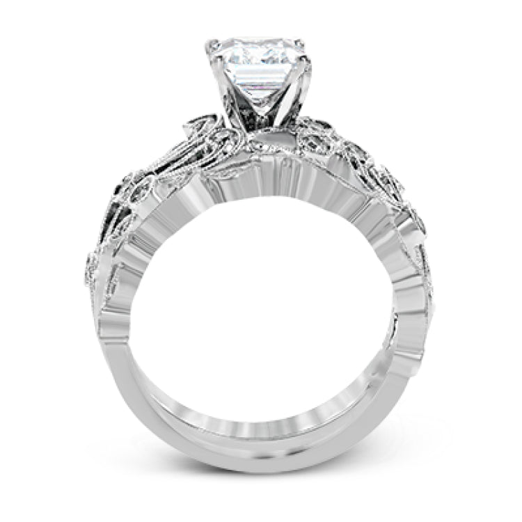 This delicate floral inspired white gold engagement ring and wedding band set is accentuated with .28 ctw shimmering round cut white diamonds.