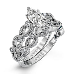 This delicate floral inspired white gold engagement ring and wedding band set is accentuated with .28 ctw shimmering round cut white diamonds.