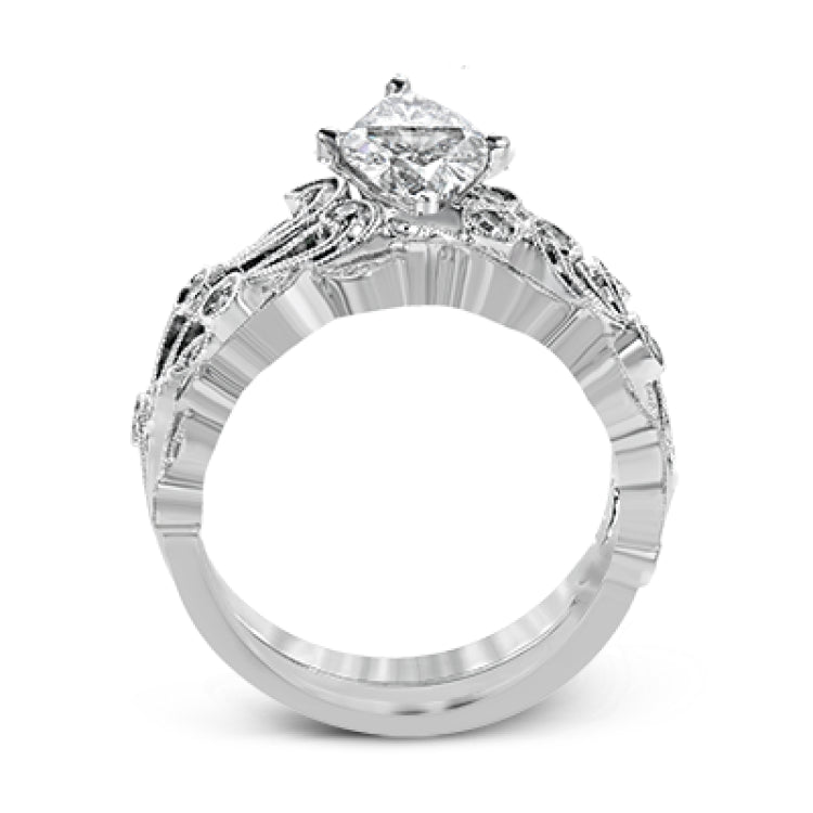 This delicate floral inspired white gold engagement ring and wedding band set is accentuated with .28 ctw shimmering round cut white diamonds.