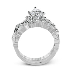 This delicate floral inspired white gold engagement ring and wedding band set is accentuated with .28 ctw shimmering round cut white diamonds.