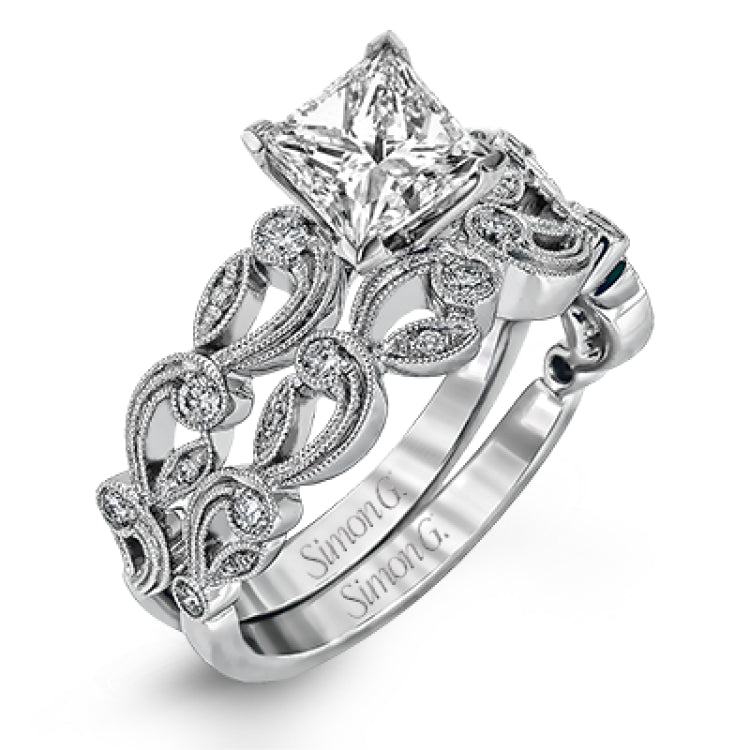 This delicate floral inspired white gold engagement ring and wedding band set is accentuated with .28 ctw shimmering round cut white diamonds.