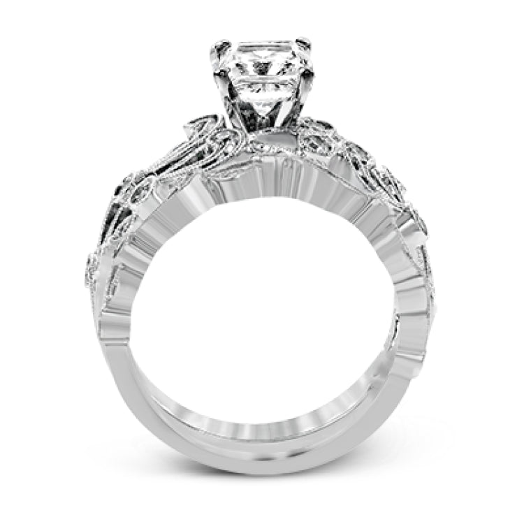 This delicate floral inspired white gold engagement ring and wedding band set is accentuated with .28 ctw shimmering round cut white diamonds.
