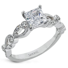This delicate floral inspired white gold engagement ring and wedding band set is accentuated with .28 ctw shimmering round cut white diamonds.