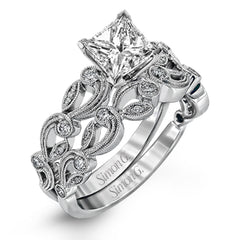 This delicate floral inspired white gold engagement ring and wedding band set is accentuated with .28 ctw shimmering round cut white diamonds.