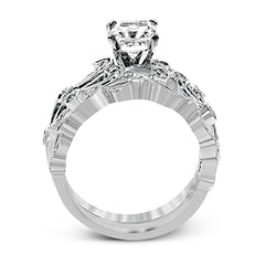 This delicate floral inspired white gold engagement ring and wedding band set is accentuated with .28 ctw shimmering round cut white diamonds.