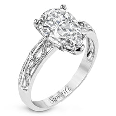 A whimsical openwork design glimmers with .04 ctw of round white diamonds in this charmingly beautiful white gold engagement ring.