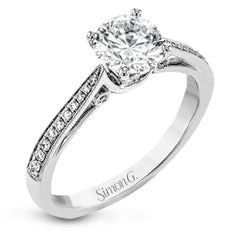 Sleek and lovely, this white gold engagement ring has an elegant design enhanced with .14 ctw of round white diamonds.
