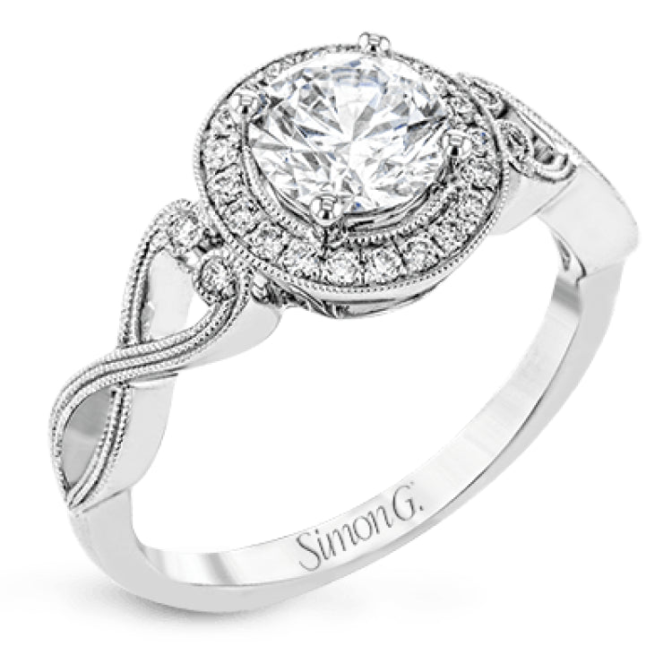 This remarkably beautiful white gold ring features intricate milgrain details alongside a lovely halo of .06 ctw of round white diamonds.