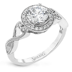 This remarkably beautiful white gold ring features intricate milgrain details alongside a lovely halo of .06 ctw of round white diamonds.